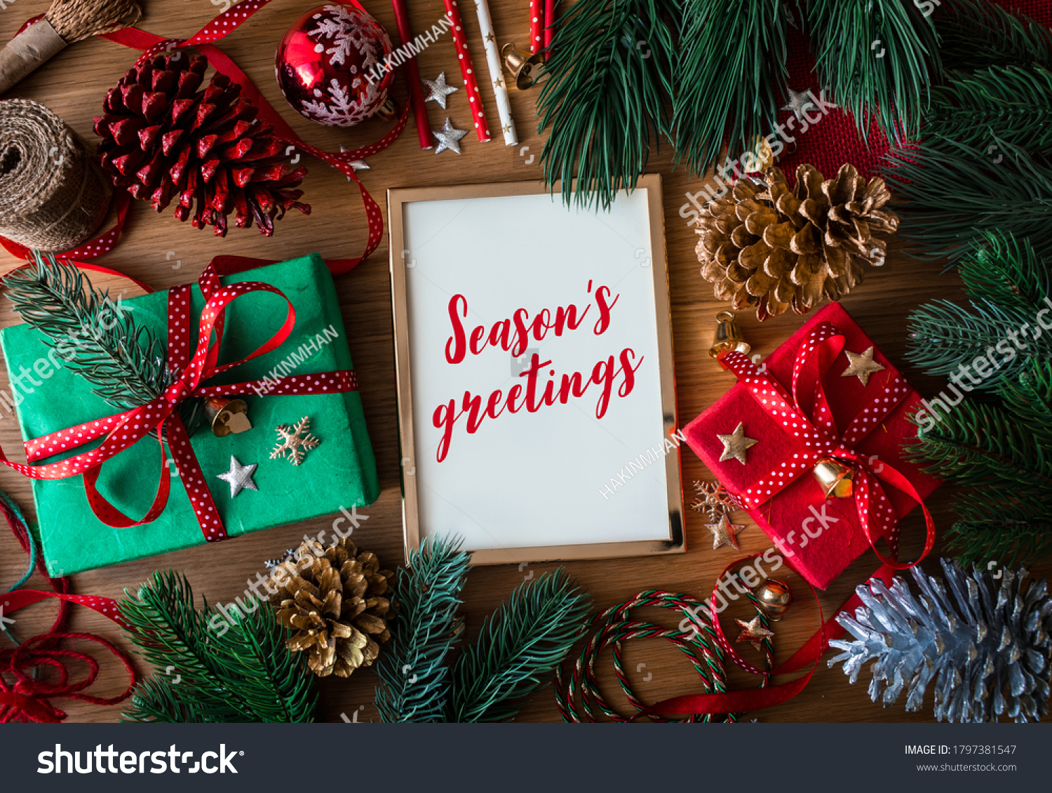 Season's greetings text on cards with gift box present and ornament element on wood table background.winter season activity ideas #1797381547