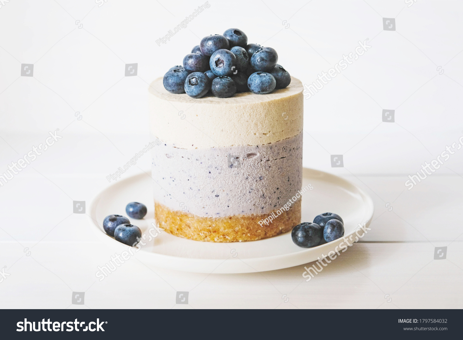 Raw gluten-free no-bake dessert. Vegan vanilla blueberry cheesecake against white background. Sweet healthy food. #1797584032