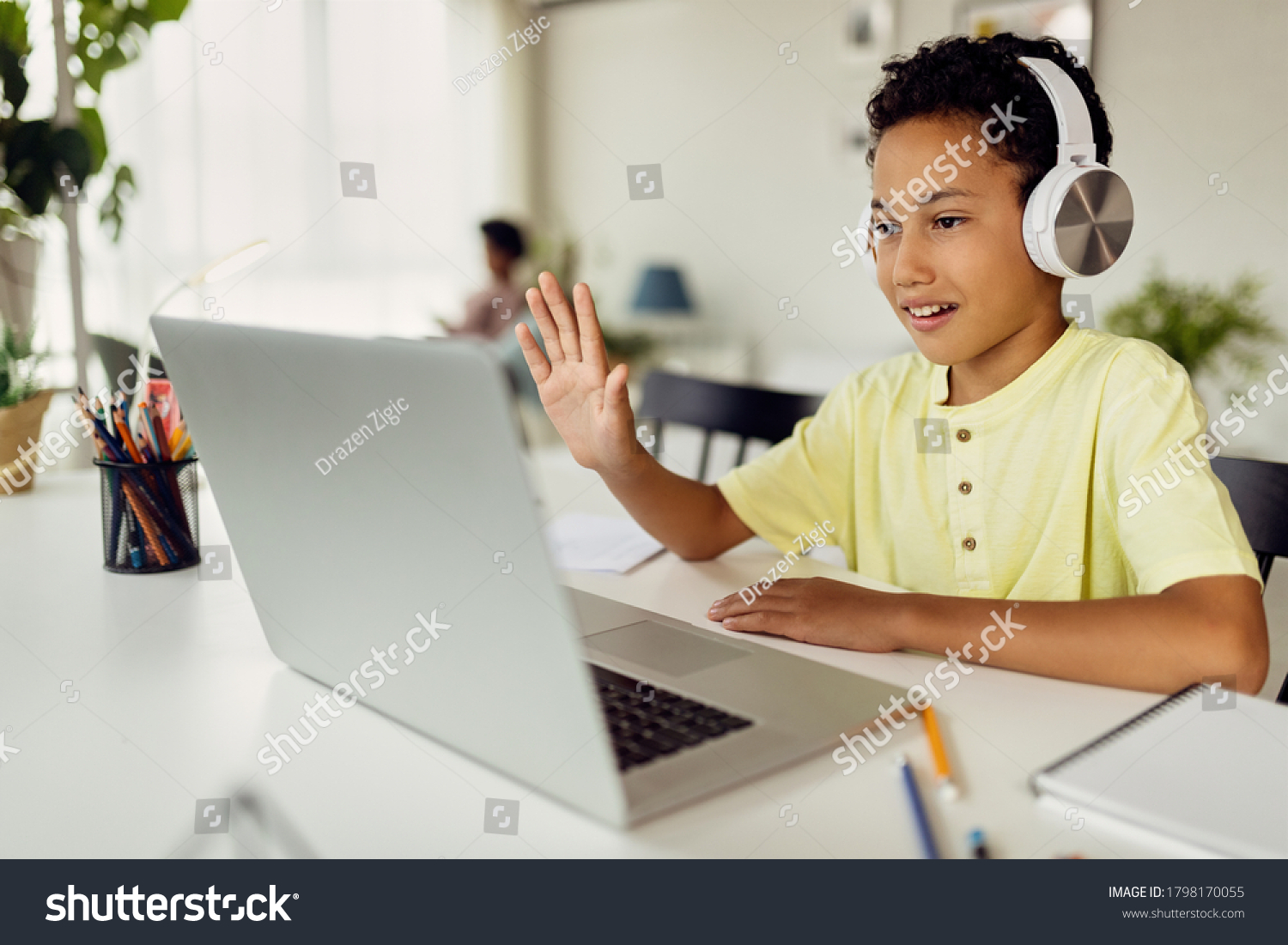 Smiling black boy making video call over laptop and waving while e-learning at home.  #1798170055