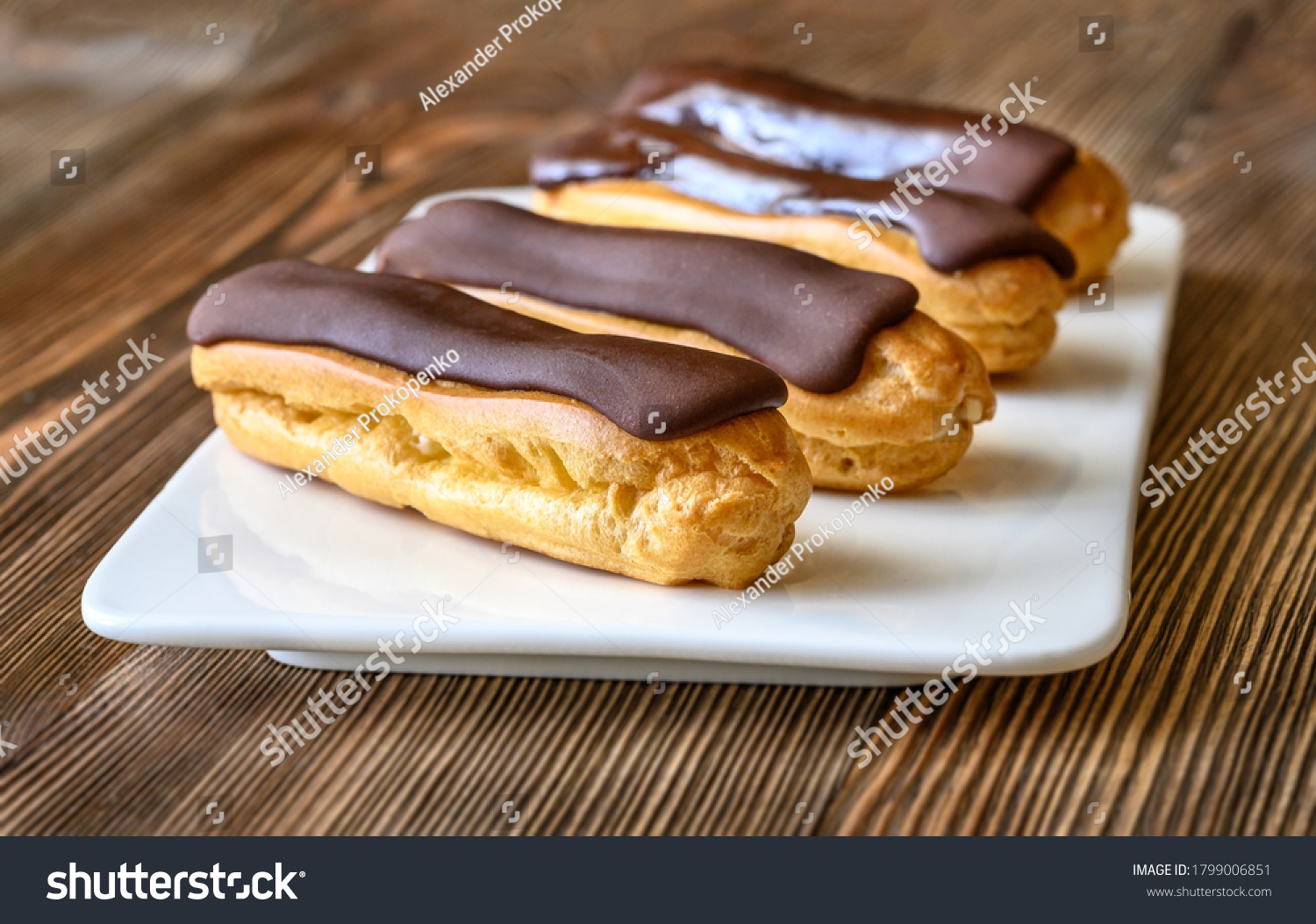 Eclairs with chocolate topping on serving plate #1799006851