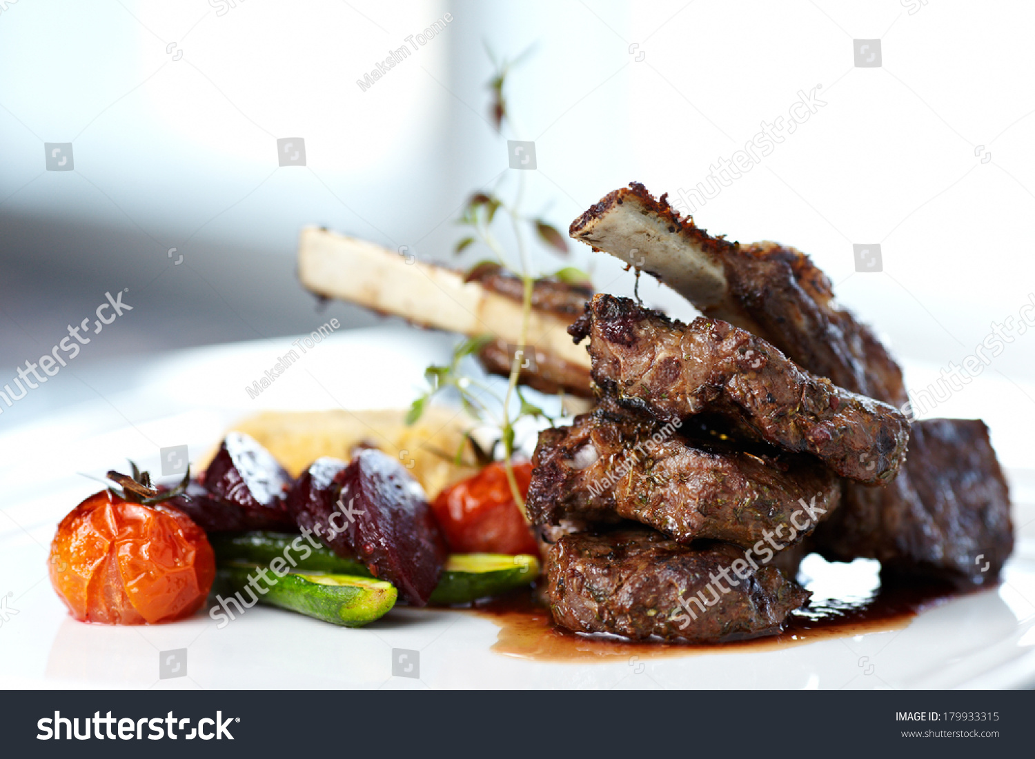 Grilled lamb carre with warm couscous salad, roasted vegetables, Dijon mustard and red wine sauce #179933315