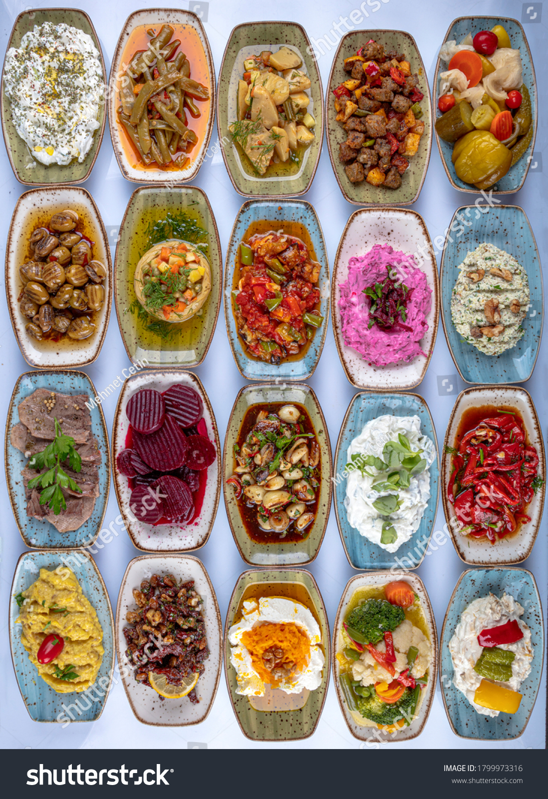 Traditional Turkish and Greek dinner meze table. Turkish Cuisine Cold Appetizers (appetizers with olive oil). Turkish appetizers in colorful plates. yogurt and various boiled herbs #1799973316