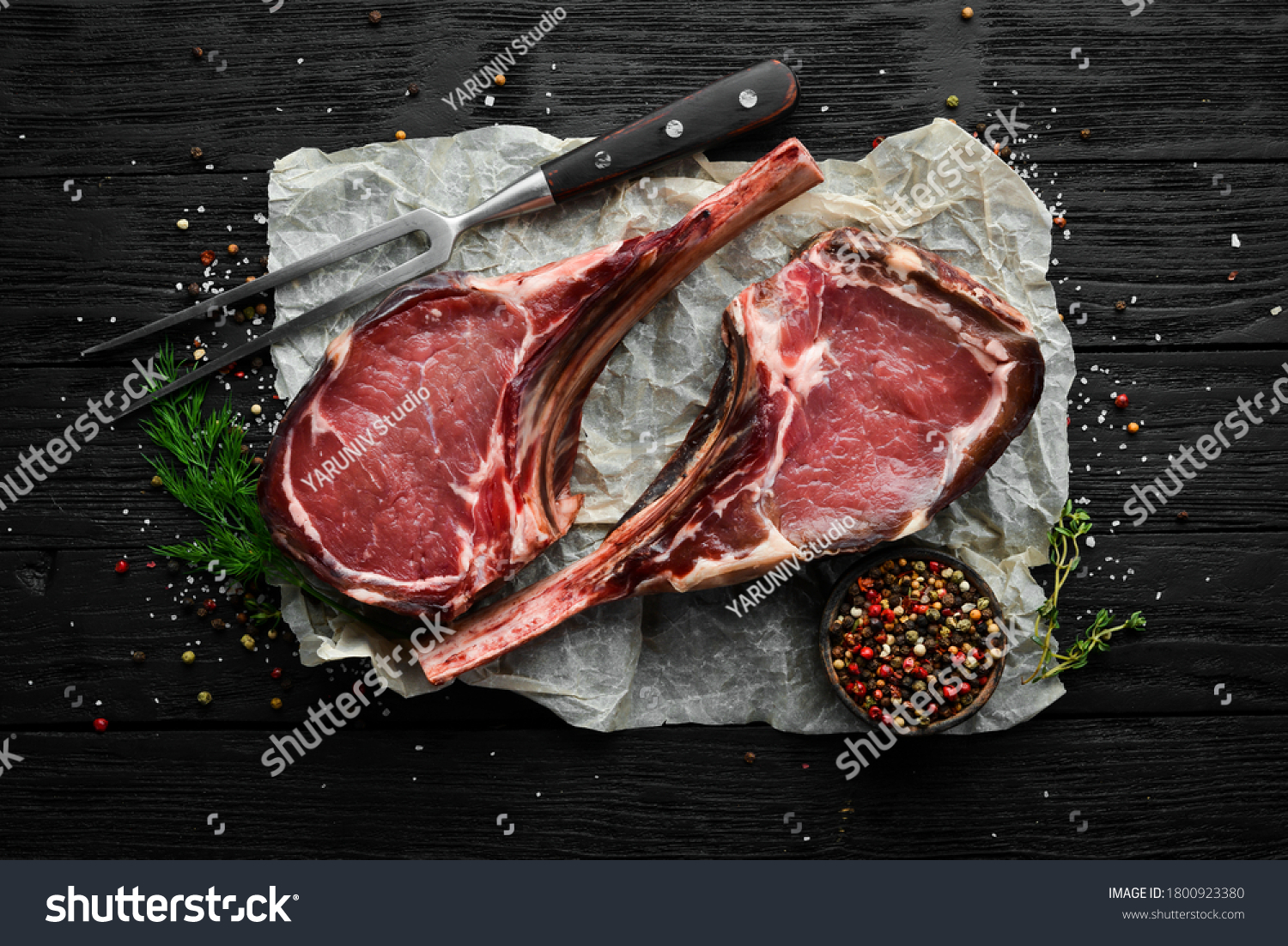 Dry aged raw tomahawk beef steak with spices. On a black wooden background. Top view. Free copy space. #1800923380