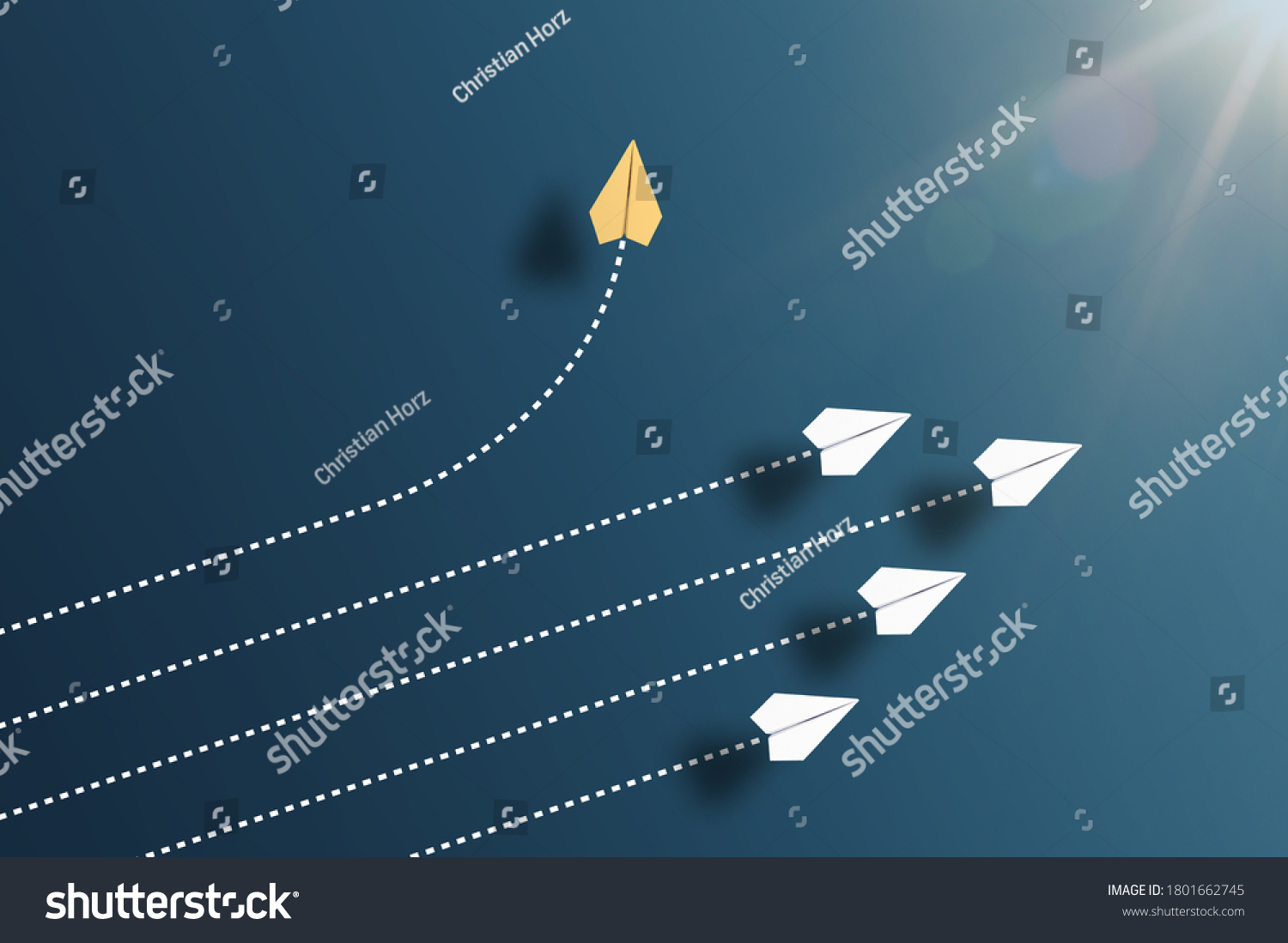 paper planes flying in formation in one direction on blue background and one paper glider going in different direction, breaking new ground and stepping out of the line concept #1801662745