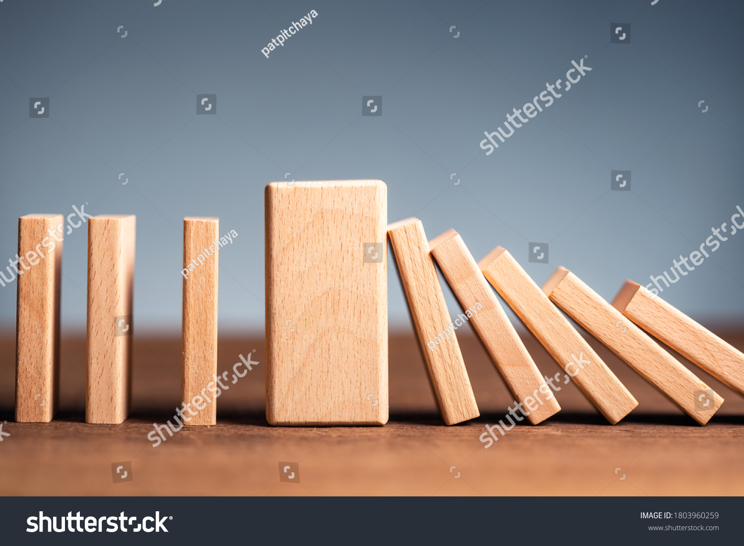 Closeup thick domino wood block in a row stop the falling, be stable in crisis, business solution concept #1803960259