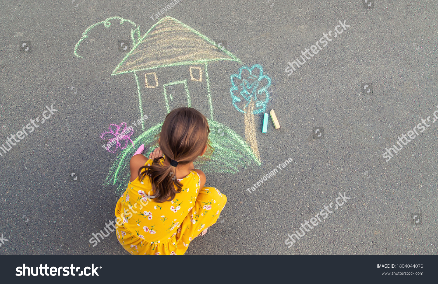 The child draws a house on the asphalt. Selective focus. kid. #1804044076