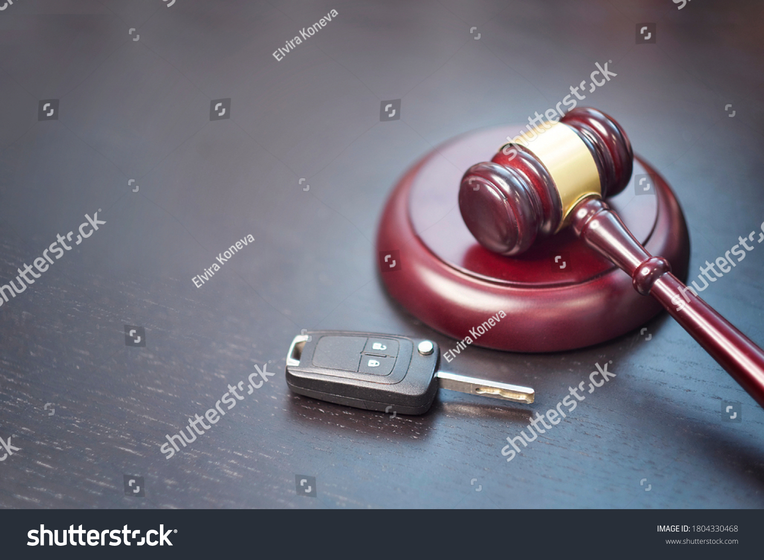 Driver license revocation concept next to the judge hammer. Traffic violation concept by car next to judge hammer. Revocable trust on a dark desk. #1804330468