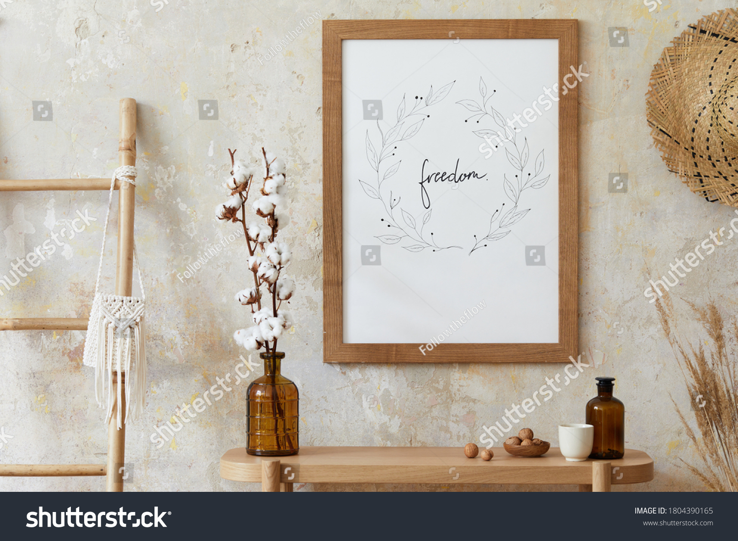 Beige boho interior of living room with mock up poster frame, elegant accessories, dried flowers in vase, wooden console and hanging rattan hut in stylish home decor. Template. #1804390165