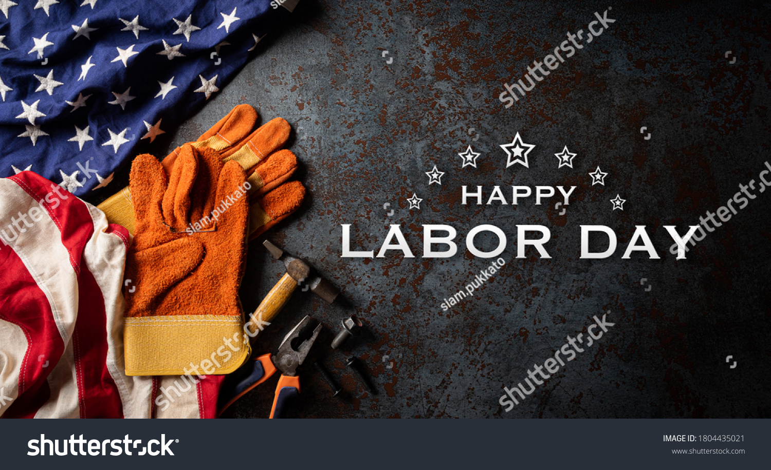 Happy Labor day concept. American flag with different construction tools on dark stone background, with copy space for text. #1804435021