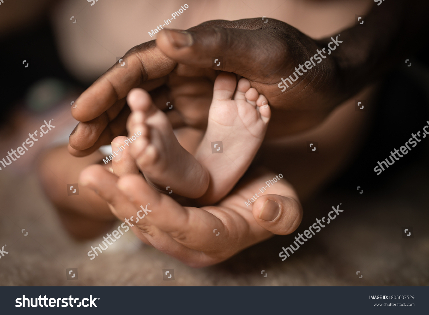 interracial family holding baby feet in hands mixed by black and white skin color #1805607529