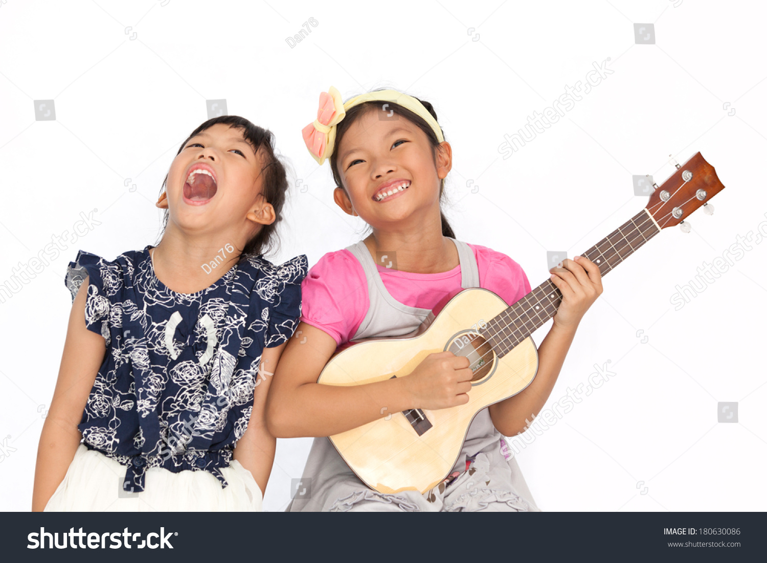 Little asian girls sing a song and playing ukulele isolate on white background #180630086