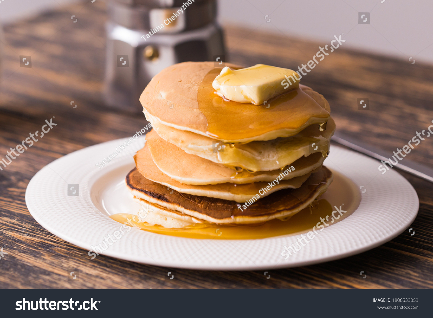 Golden pancakes with butter and warm maple syrup. #1806533053