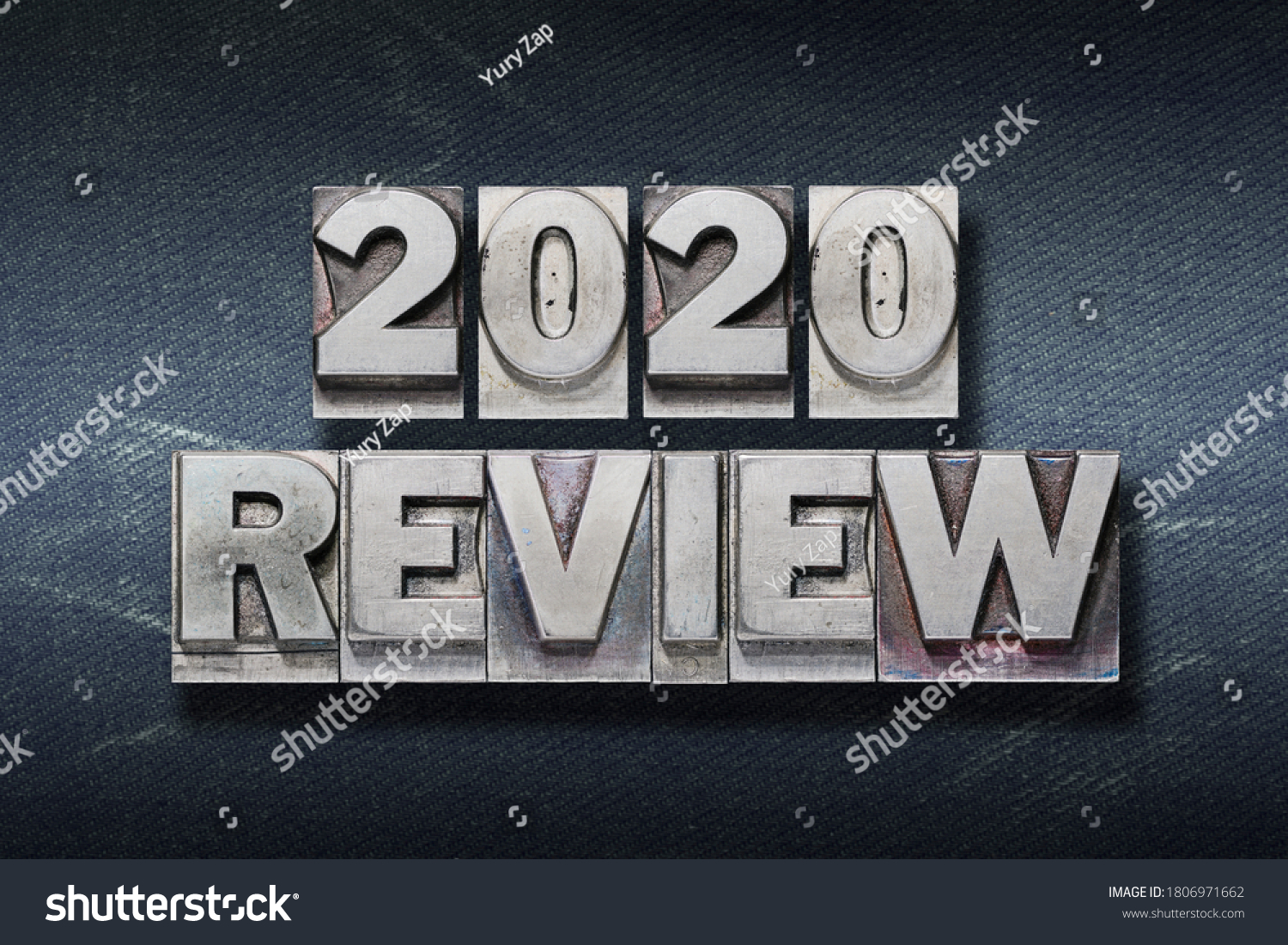 review 2020 phrase made from metallic letterpress on dark jeans background #1806971662