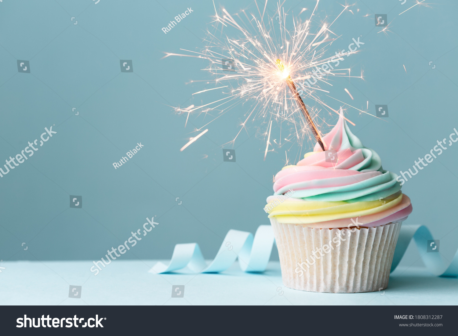 Pastel rainbow birthday cupcake with sparkler #1808312287