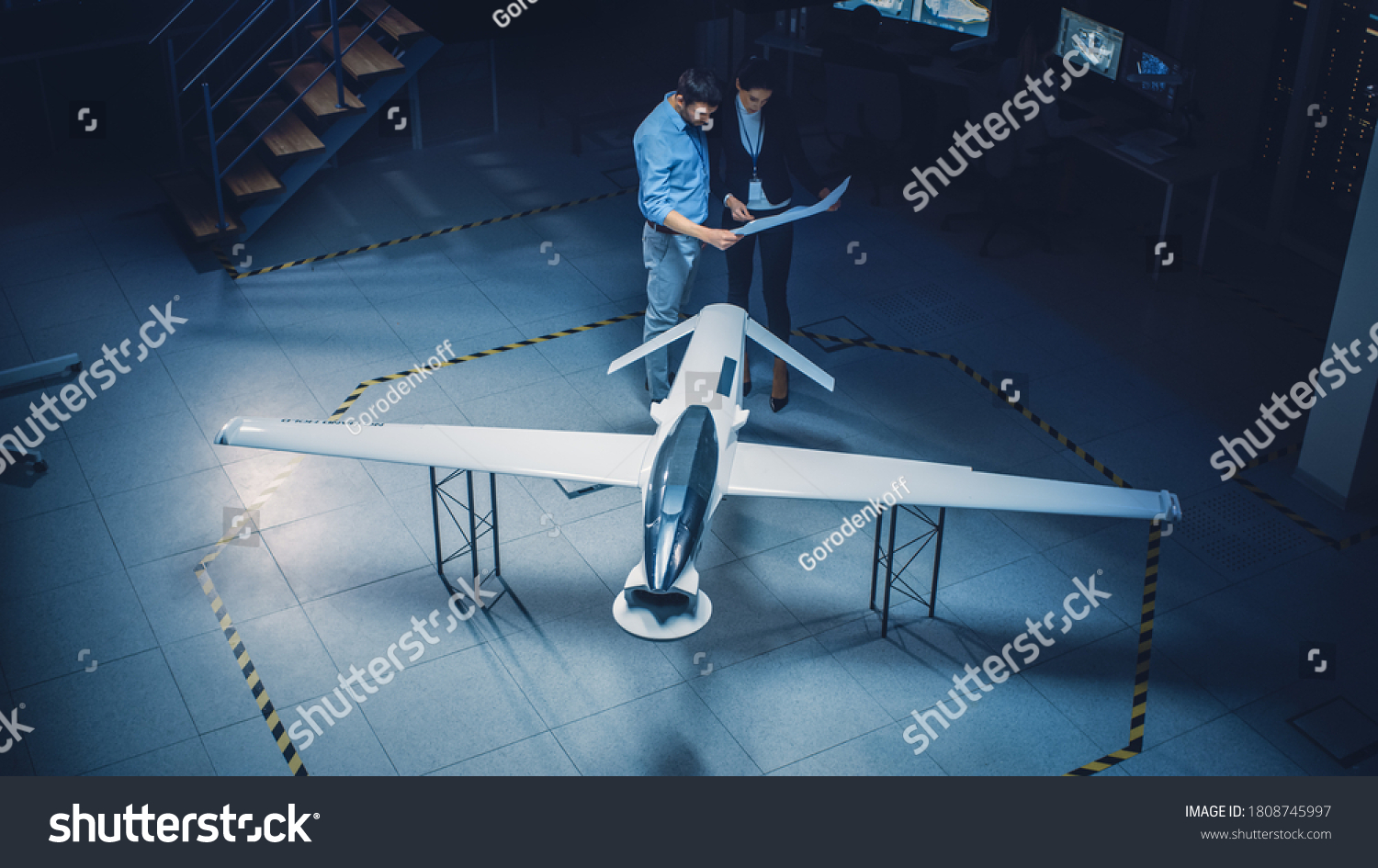 Meeting of Aerospace Engineers Work On Unmanned Aerial Vehicle / Drone Prototype. Aviation Experts have Discussion. Industrial Facility with Aircraft Capable of GPS Surveillance and Military Missions #1808745997