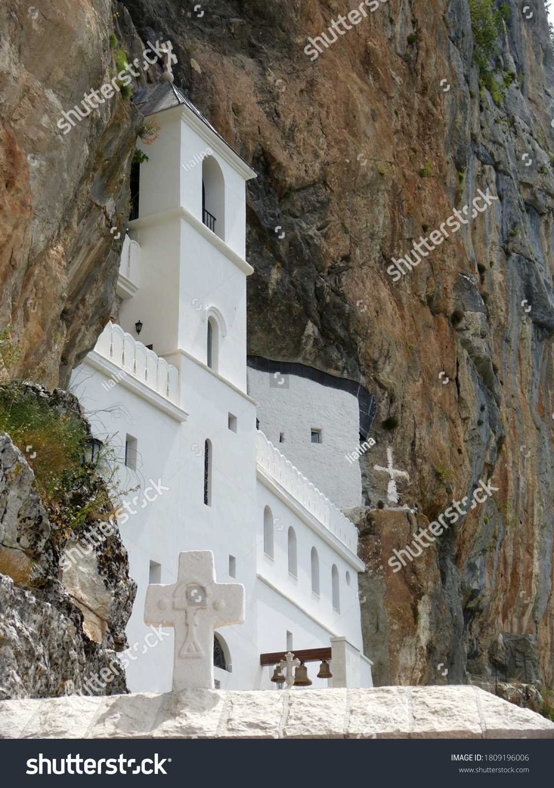Ostrog is monastery of Serbian Orthodox Church situated against an almost vertical background, high up in  large rock Ostroska Greda. Beautiful white temple on steep cliff in mountains of Montenegro. #1809196006