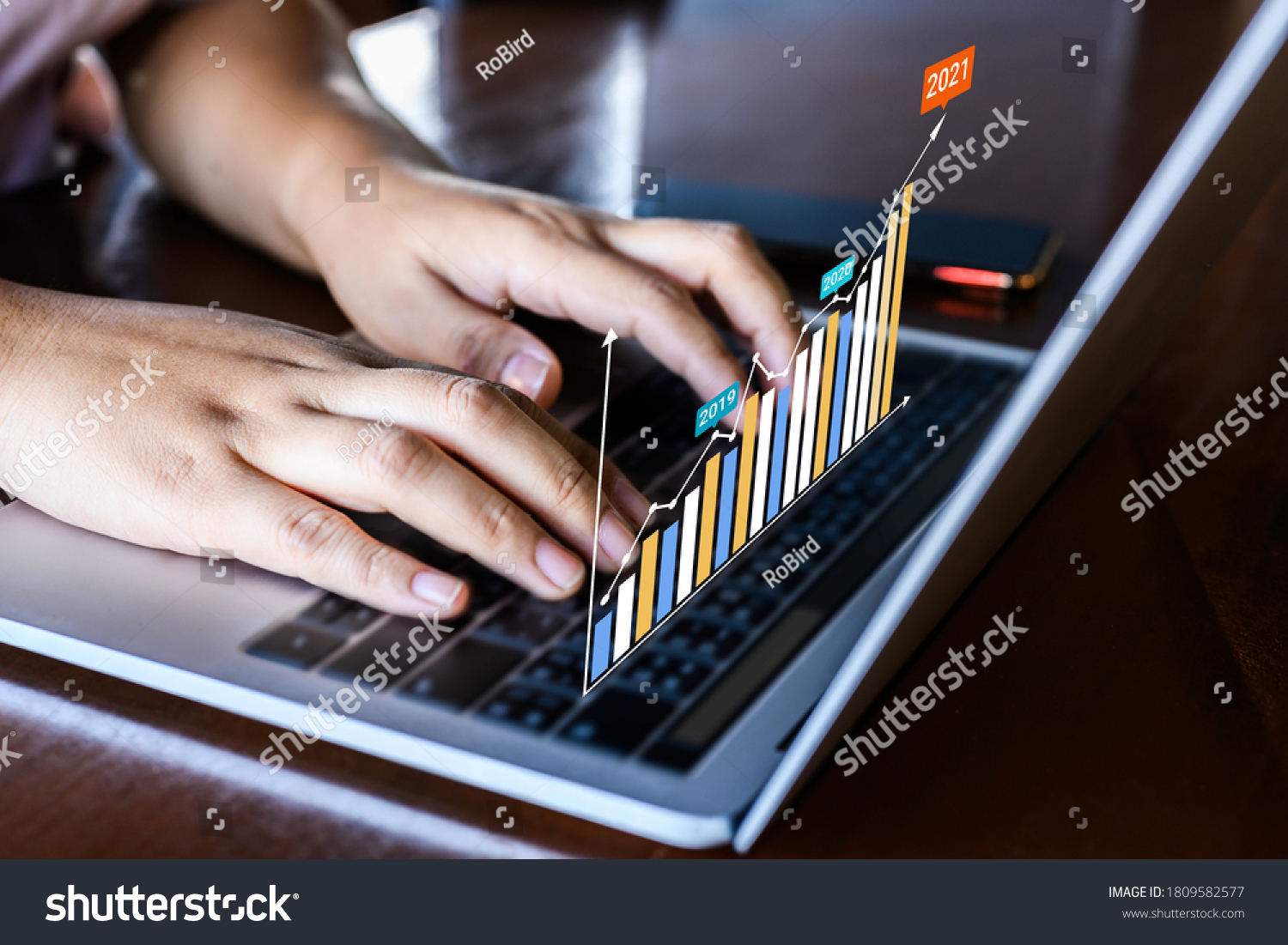 Businessman using a laptop with data analytics and statistics information business technology on table top. #1809582577