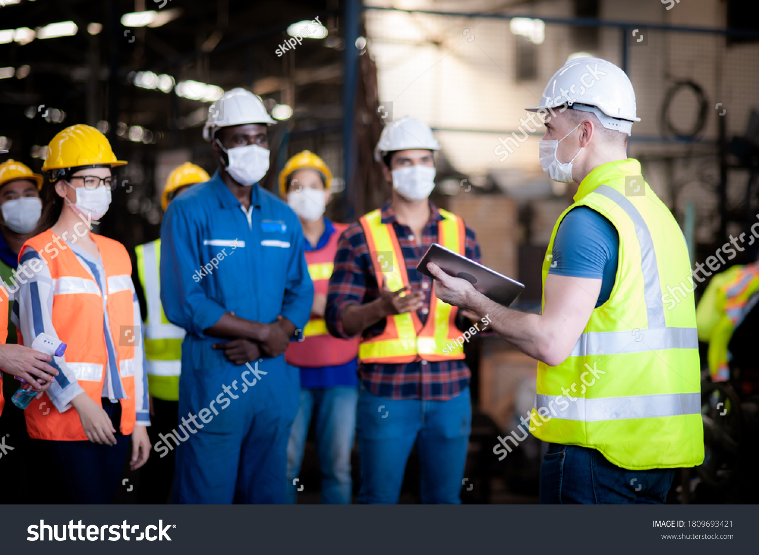 The manager leader team is assignmenting job, training for technicians, supervisor, engineers In the morning meeting before work which everyone wear masks to prevent the coronavirus and safety working #1809693421