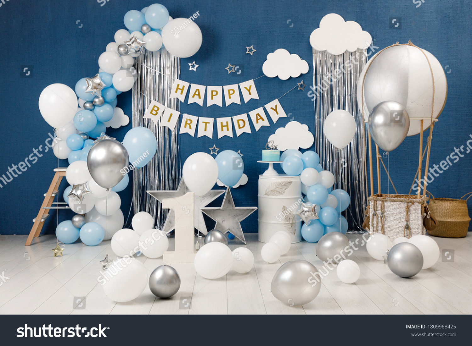 Birthday decorations - gifts, toys, balloons, garland and figure for little baby party on a blue wall background. #1809968425
