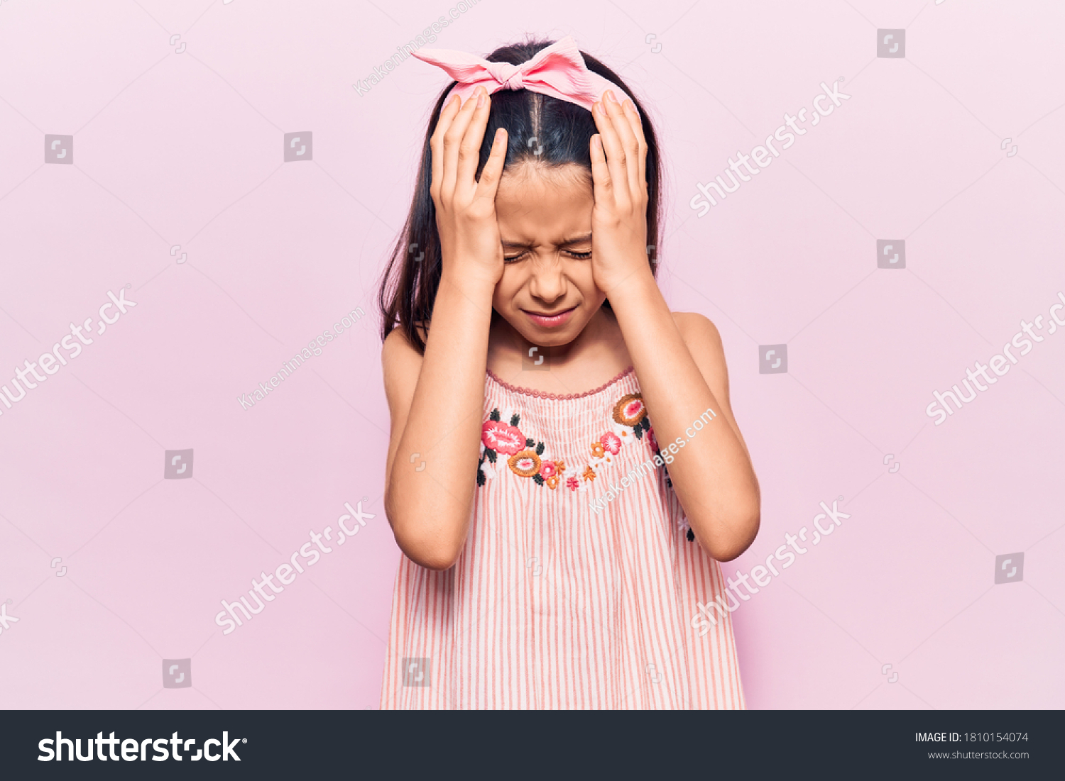 Beautiful child girl wearing casual clothes suffering from headache desperate and stressed because pain and migraine. hands on head.  #1810154074