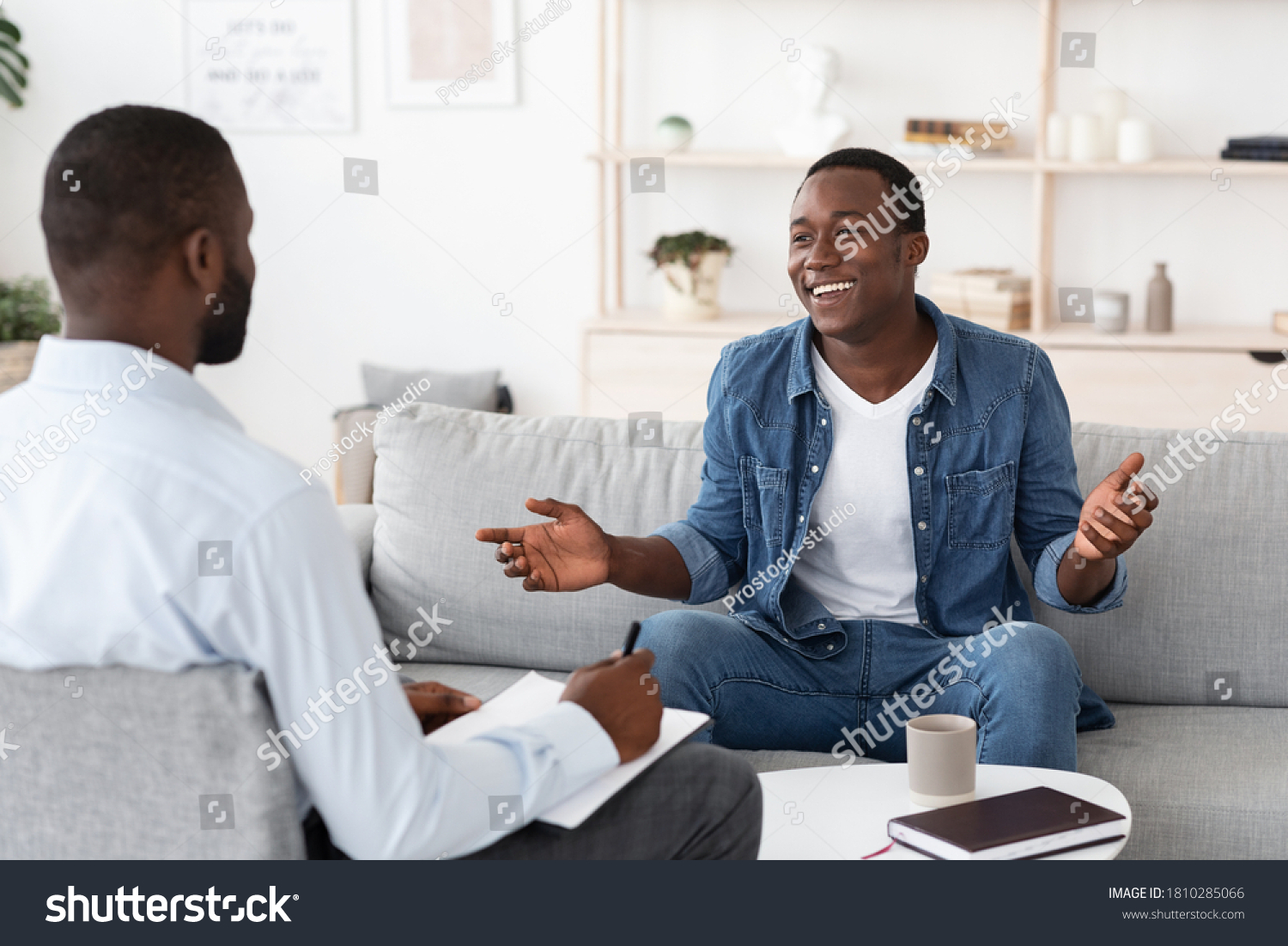 Successful Therapy. Cheerful black man talking to psychologist on meeting at his office, sharing his progress with doctor #1810285066