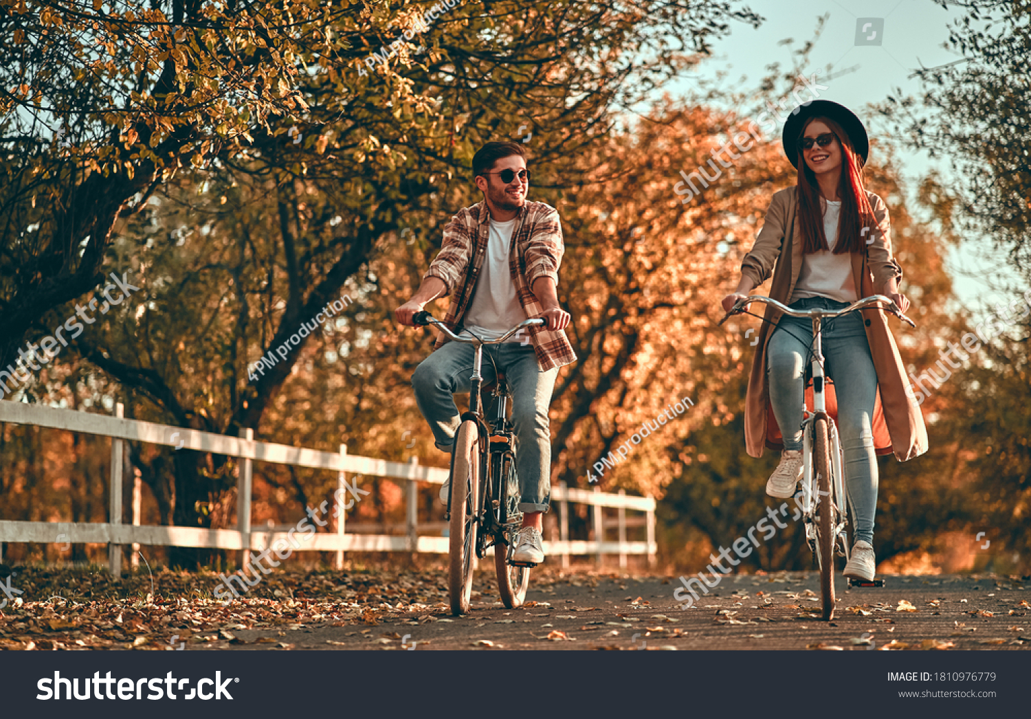 Young couple with bicycles in park in autumn time.  #1810976779