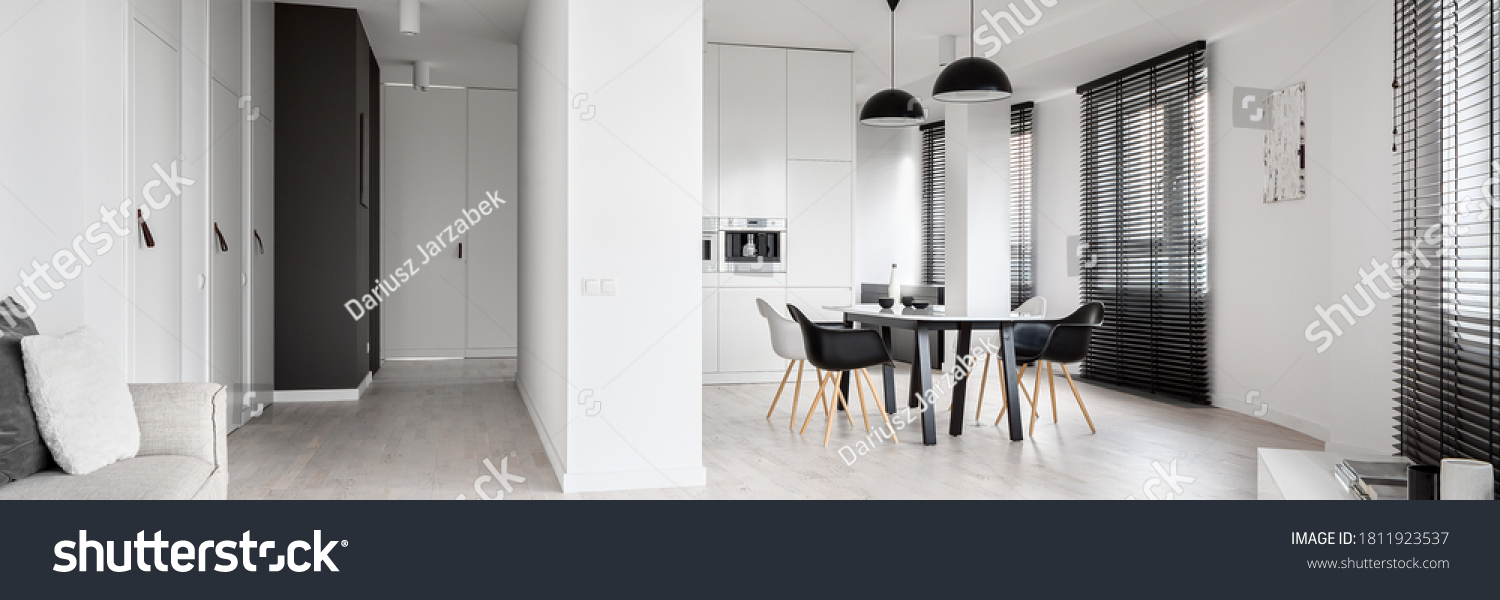 Panorama of spacious black and white apartment with many windows with long black blinds #1811923537