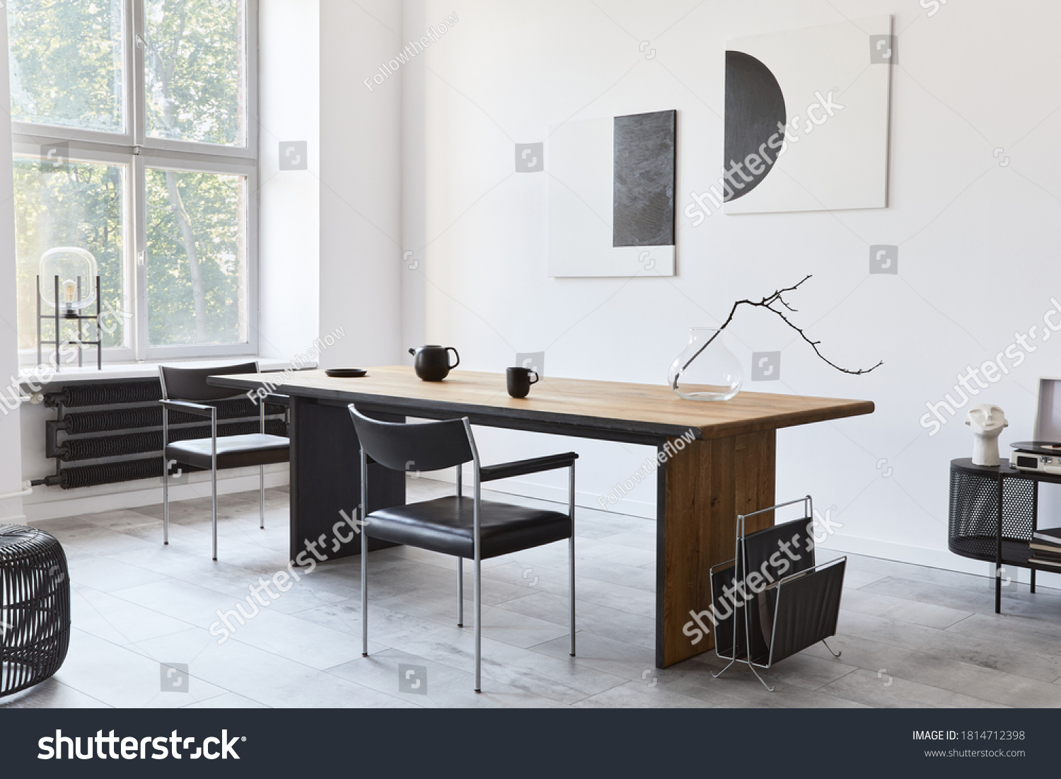 Stylish dining room interior with design wooden family table, black chairs, teapot with mug, mock up art paintings on the wall and elegant accessories in modern home decor. Template. #1814712398