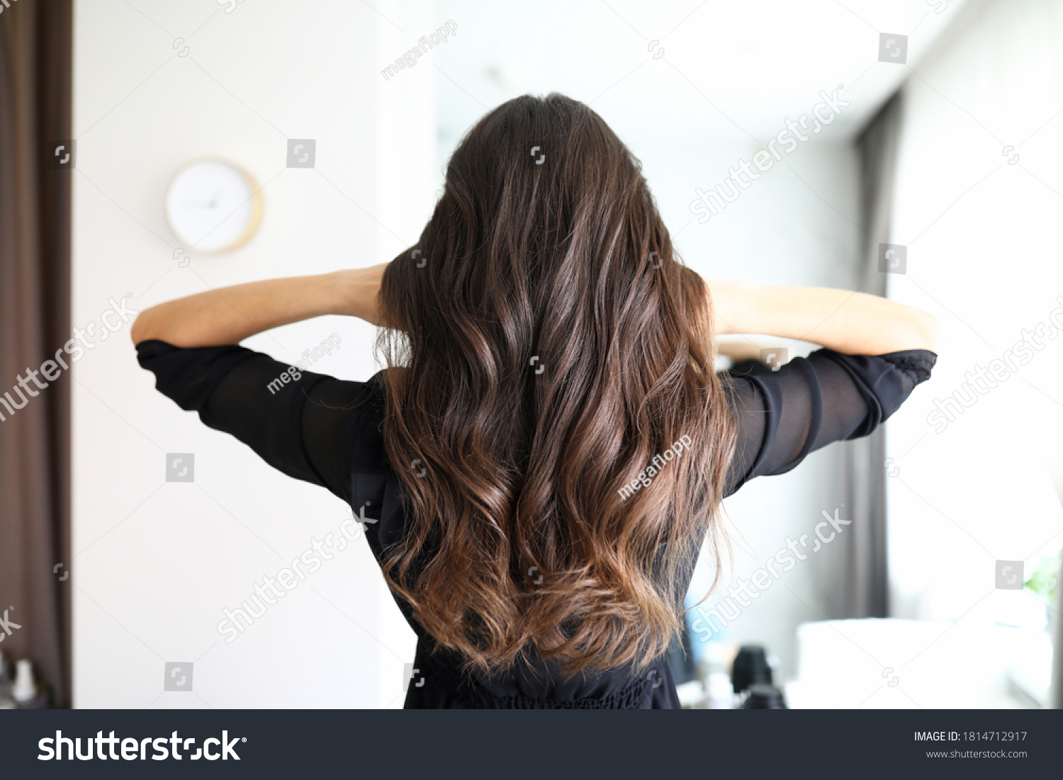 Close-up of woman after visiting hairdresser. Long curls of brunette female person. Hairdo for holiday or for everyday. Beauty salon and hairstyle concept #1814712917