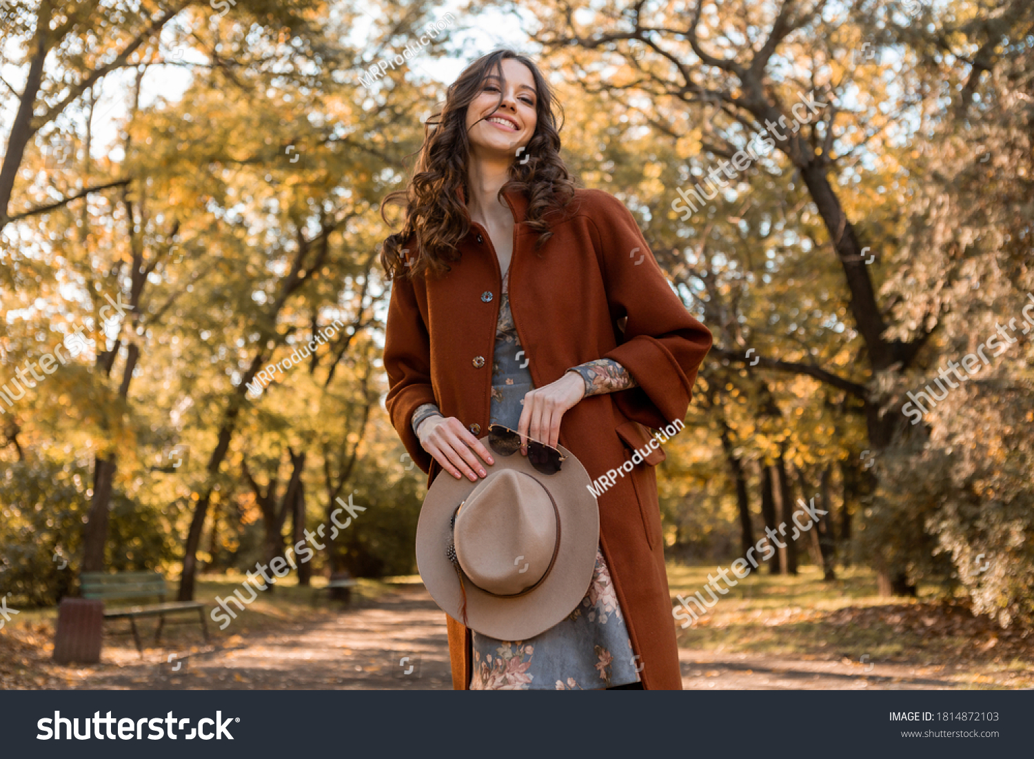 close-up hands details of attractive stylish woman holding hat and sunglasses walking in park dressed in warm coat autumn trendy street fashion style accessories #1814872103