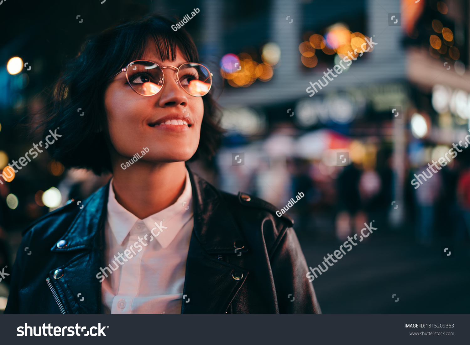 Carefree brunette young woman with short haircut in stylish eyewear for eyes protection fascinated with New York urbanity in Manhattan,youthful female in leather jacket enjoying metropolitan nightlife #1815209363