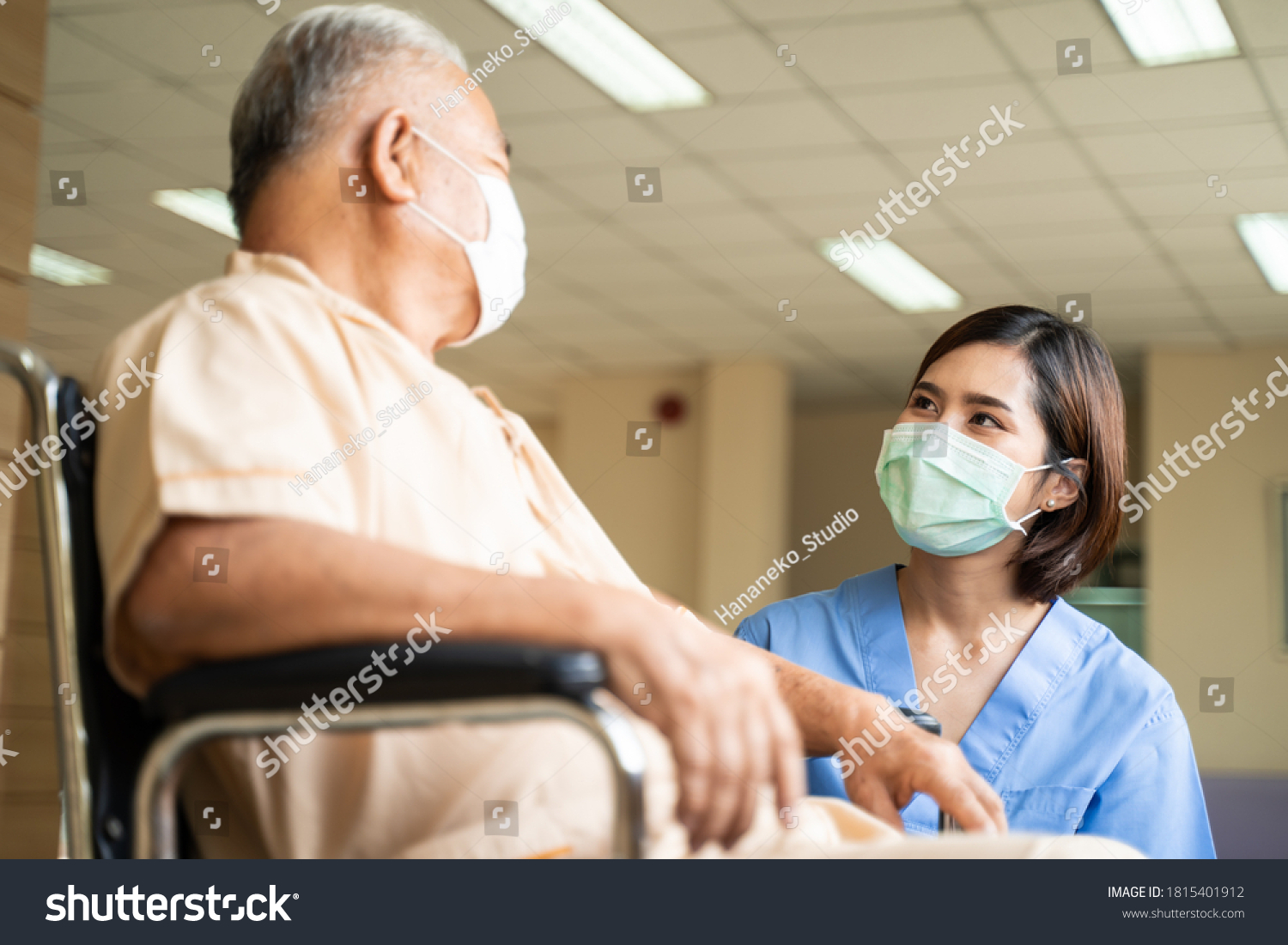 Healthcare concept, Asian nurse taking care and talking of mature male patient sitting on wheelchair in hospital. Woman and senior man wearing surgical face mask for protection of The COVID infection. #1815401912