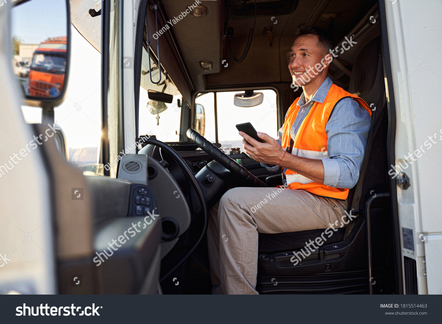 Forwarder or truck driver in drivers cap holding mobile phone #1815514463