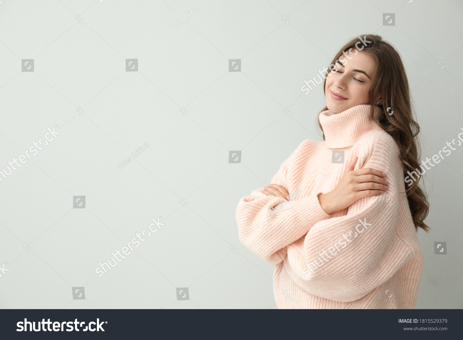 Beautiful young woman wearing warm pink sweater on light background. Space for text #1815529379