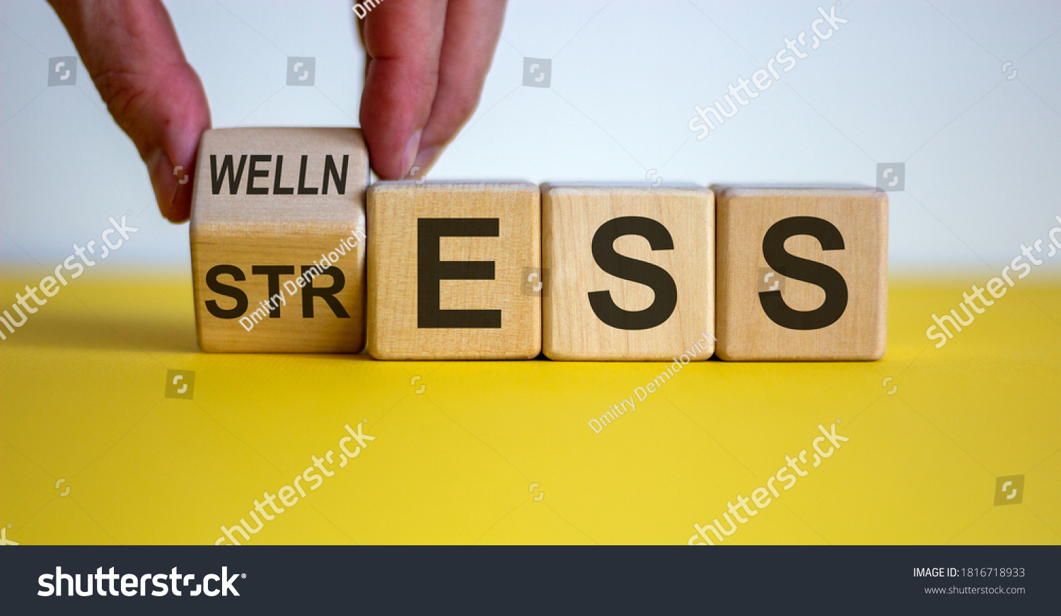 Wellness instead of stress. Hand turns a cube and changes the word 'stress' to 'wellness'. Beautiful yellow table, white background. Concept. Copy space. #1816718933