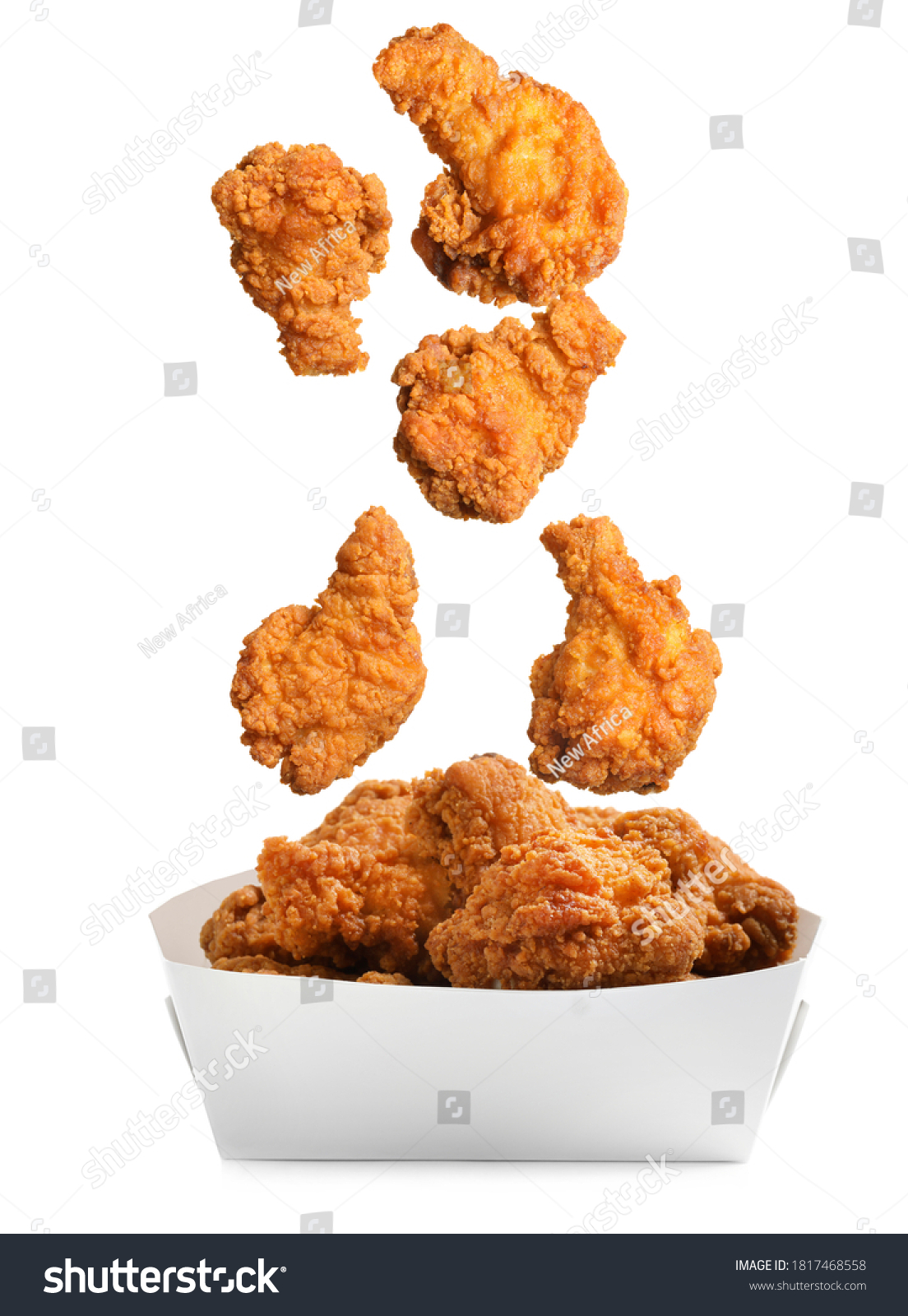 Fresh fried chicken falling into container on white background #1817468558