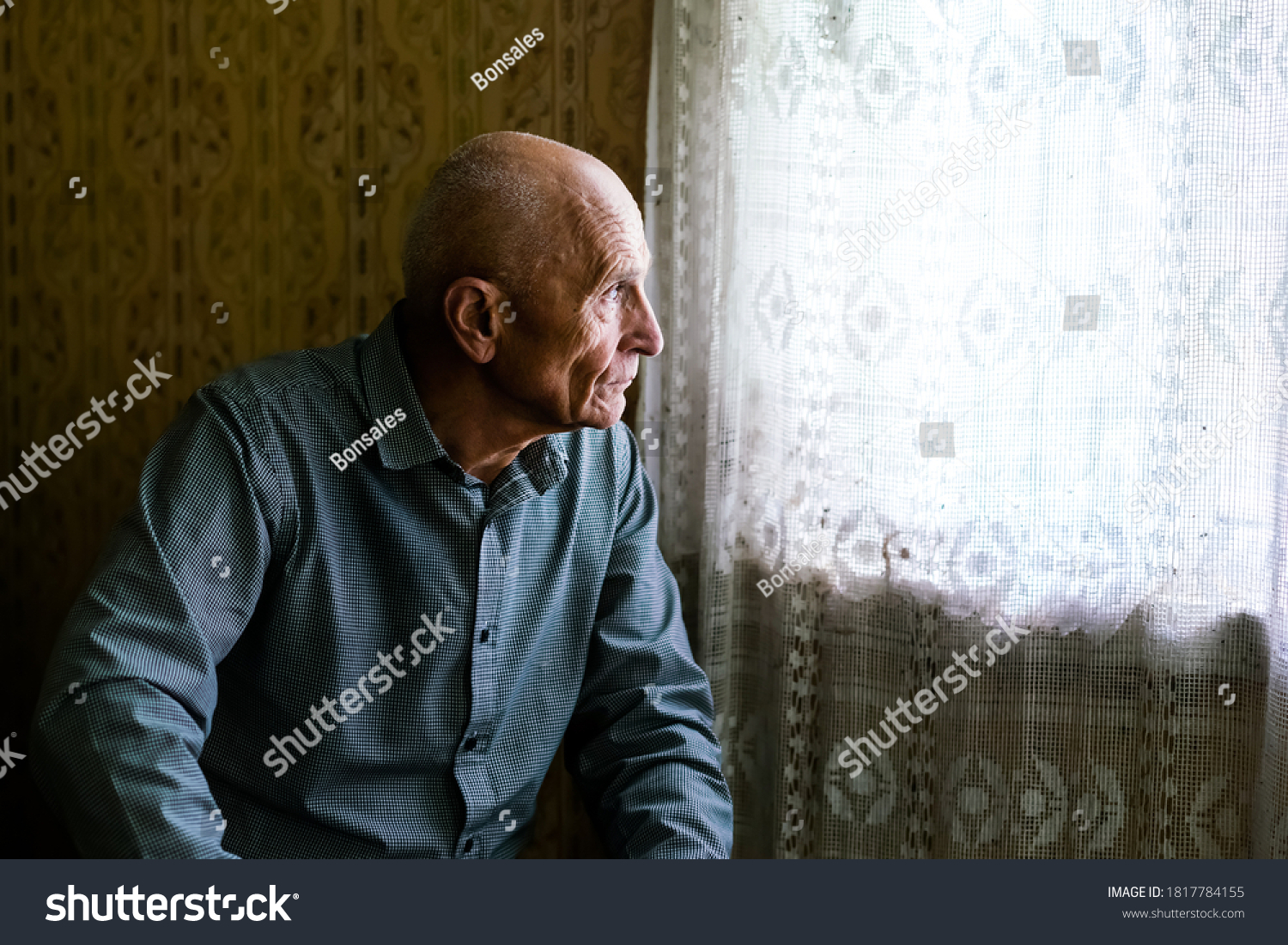 older sad bald man siting on sofa in village house and looking to window senior persons concept #1817784155