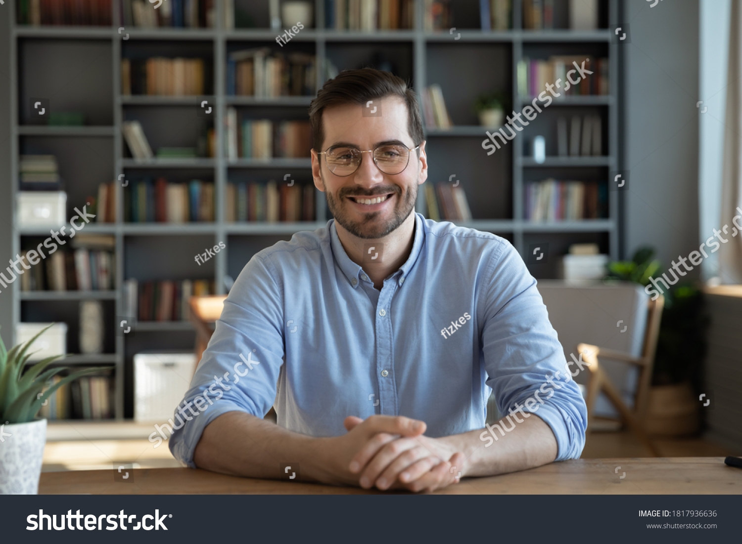 Headshot portrait of smiling 30s Caucasian millennial man in glasses sit at desk at home talk speak on video call or webcam virtual conference. Picture of happy young male in spectacles pose at table. #1817936636