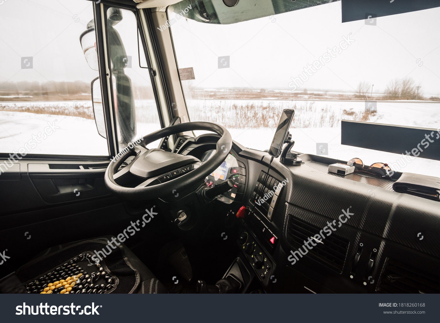 The driver's seat in the cab of the truck, inside view #1818260168