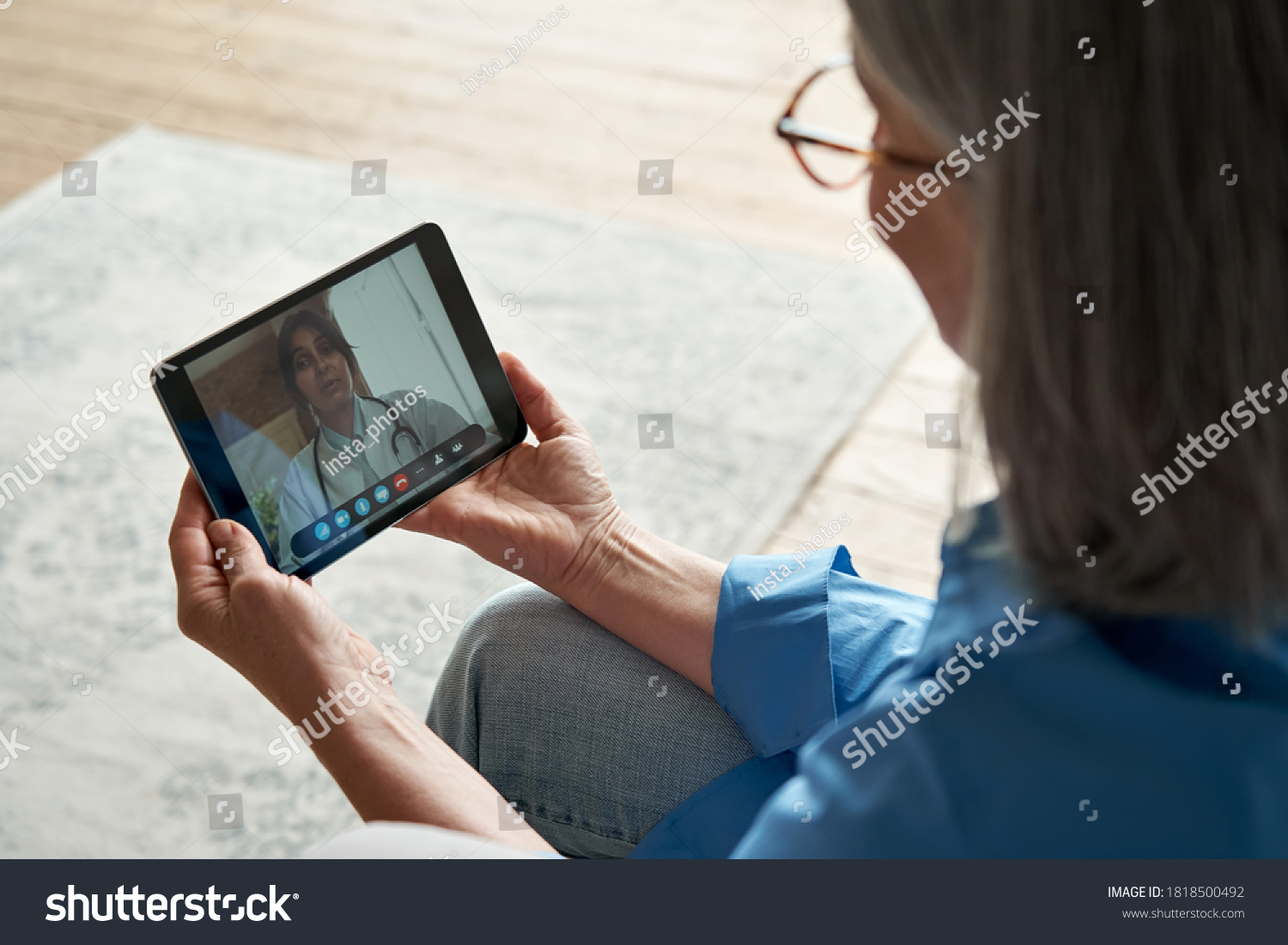 Over shoulder closeup view of old woman patient video calling virtual doctor using tablet at home. Online telemedicine chat meeting. Seniors ehealth, telehealth consultation, tele medicine concept. #1818500492