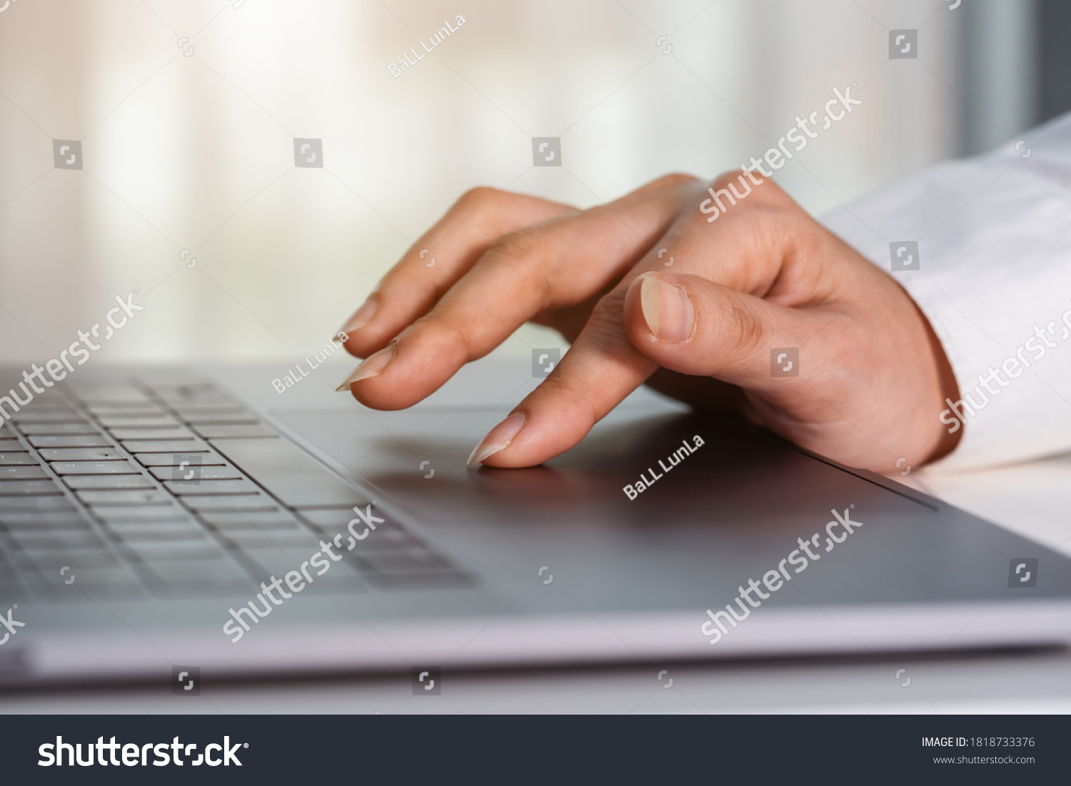 close-up female hand touching touchpad on a laptop computer #1818733376