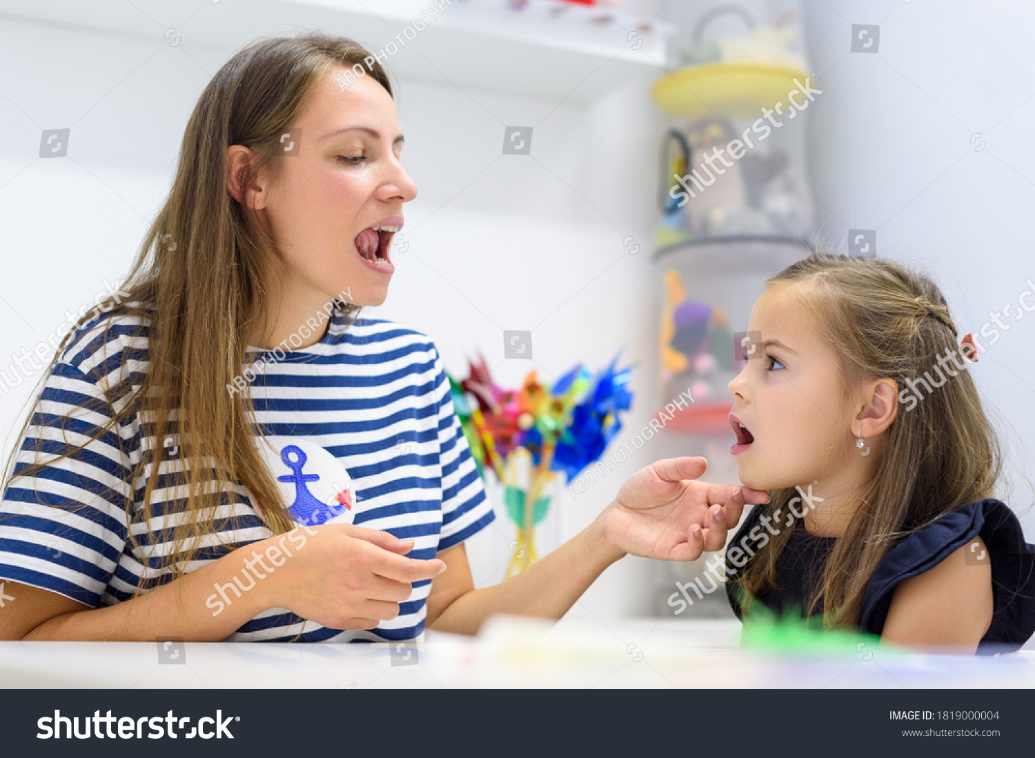 Children speech therapy concept. Preschooler practicing correct pronunciation with a female speech therapist.  #1819000004