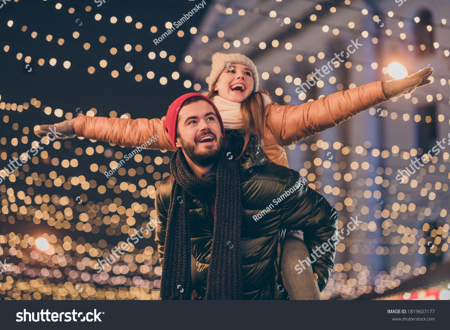 Photo of positive couple having fun christmas x-mas around evening outside illumination boyfriend piggyback girlfriend holding hands fly #1819607177