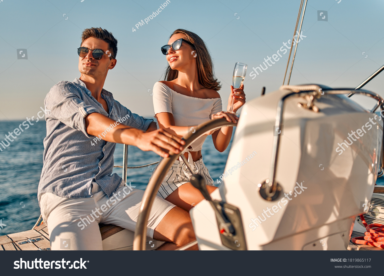 Group of friends relaxing on luxury yacht. Having fun together while sailing in the sea. Romantic couple sitting near steering wheel. Traveling and yachting concept. #1819865117