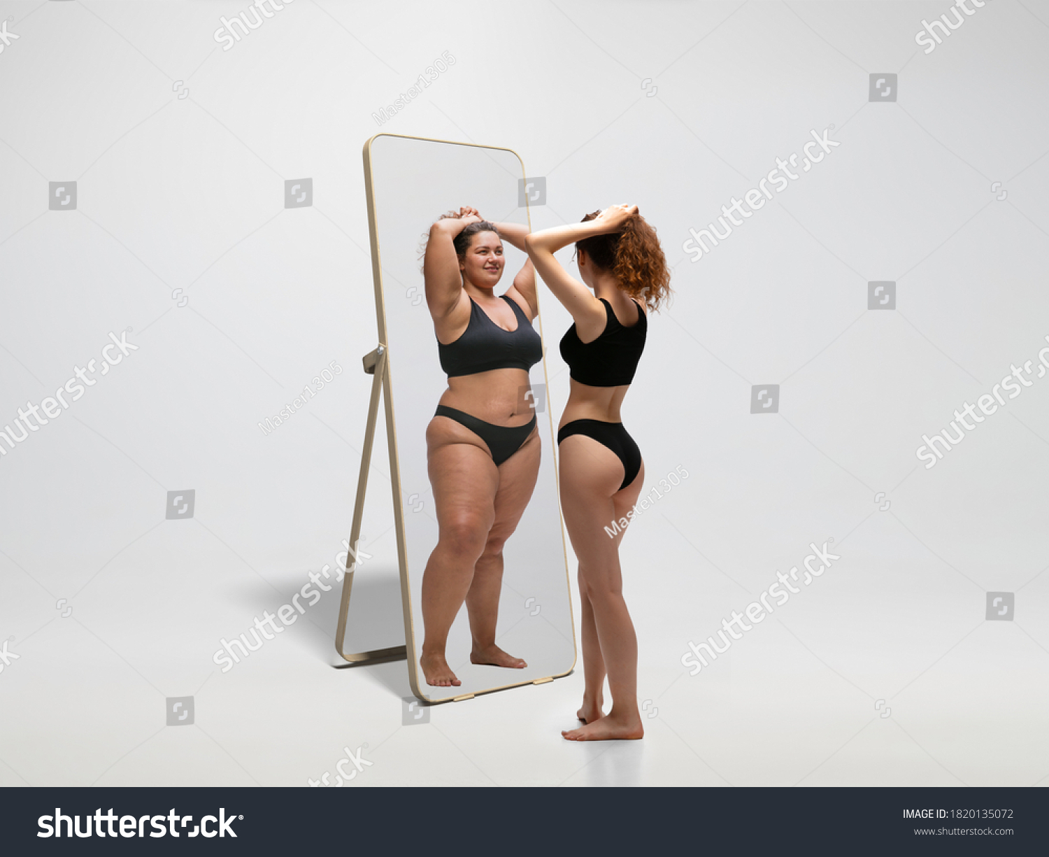 Young fit, slim woman looking at fat girl in mirror's reflection on white background. Thinking she's not enough sportive. Concept of healthy lifestyle, fitness, sport, nutrition and body positive. #1820135072
