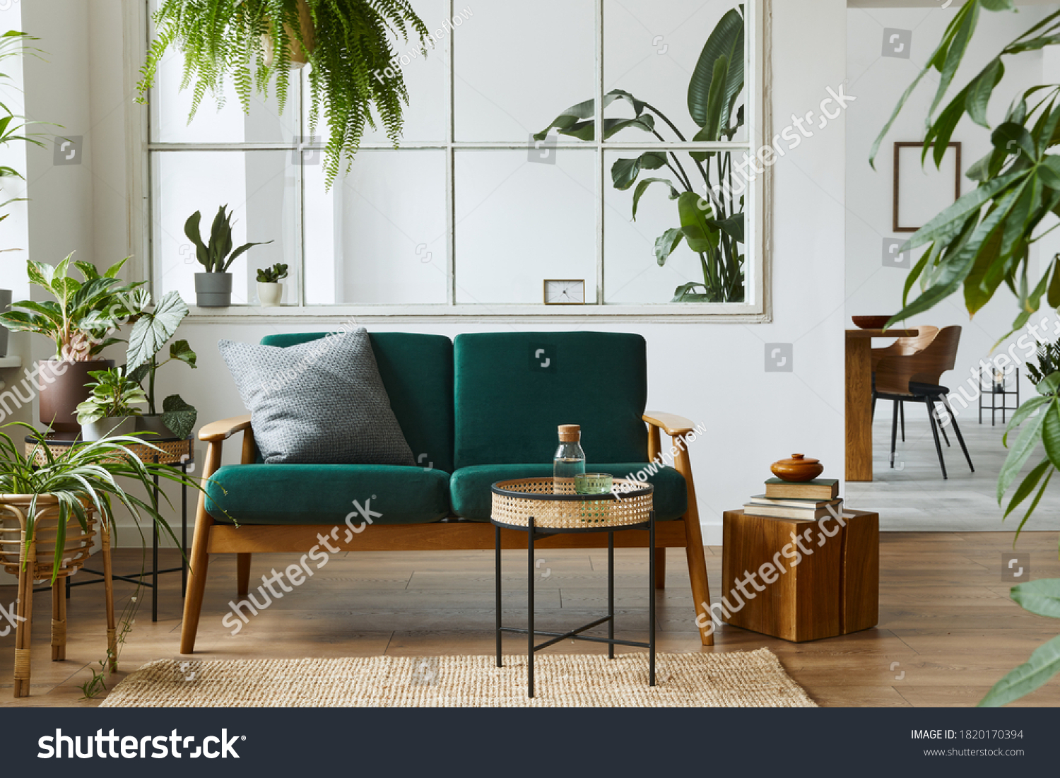 Stylish scandinavian living room interior with green velvet sofa, coffee table, carpet, plants, furniture, elegant accessories in modern home decor. Template. #1820170394