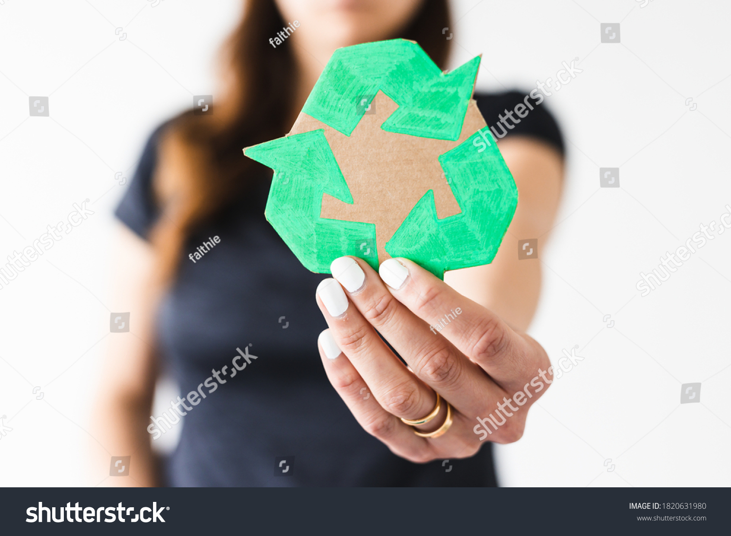 sustainable development concept, woman holding a recycle sign towards the camera shot at shallow depth of field #1820631980