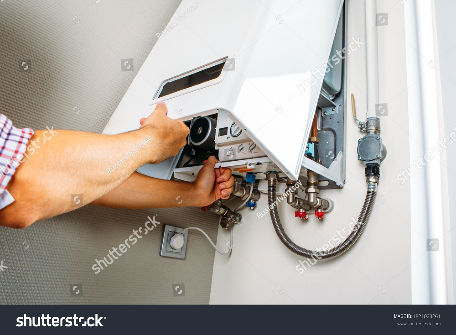 Plumber attaches Trying To Fix the Problem with the Residential Heating Equipment. Repair of a gas boiler #1821023261