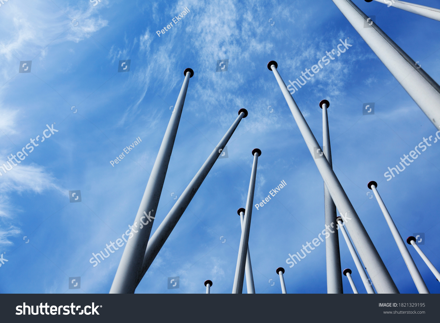 lots of empty flagpoles against a blue sky #1821329195