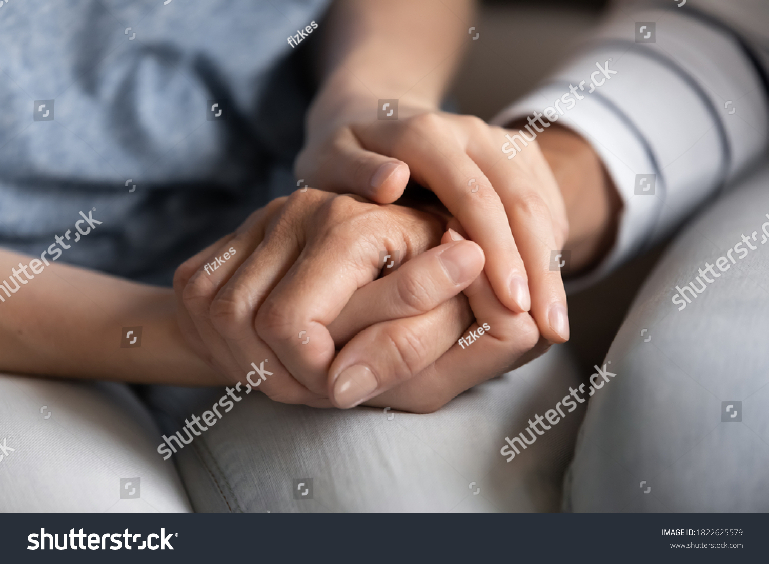 I know you can. Close up of millennial woman grown daughter, grandchild or younger friend holding tight hand of old mother, grandmother, elder relative or colleague helping to overpass life problems #1822625579